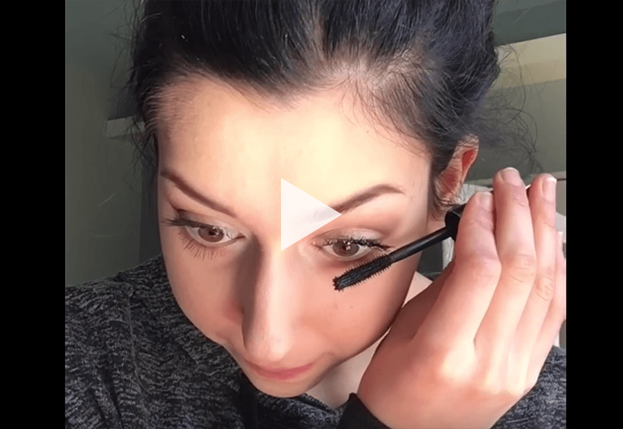 girl putting on mascara