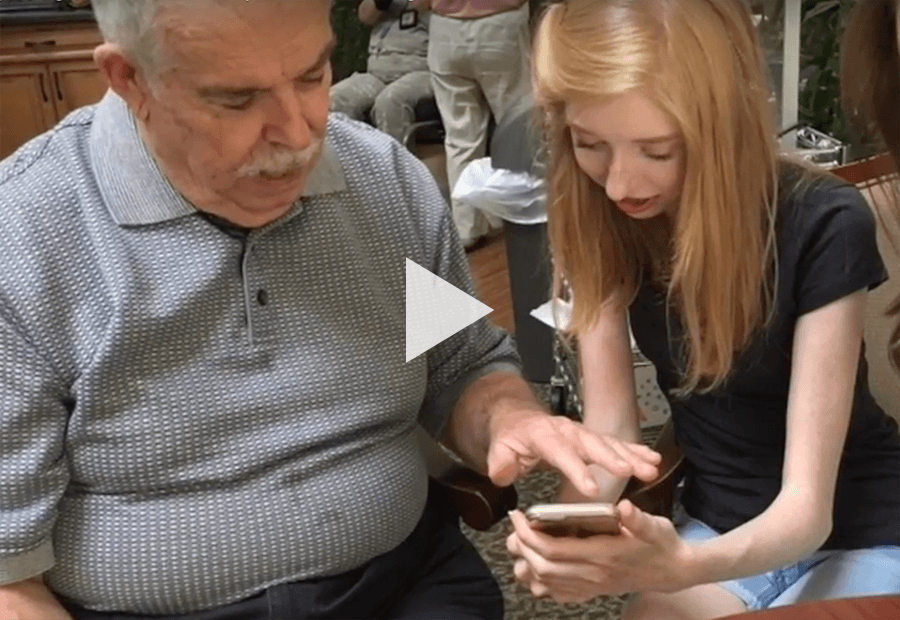 teen teaching elder man use technology